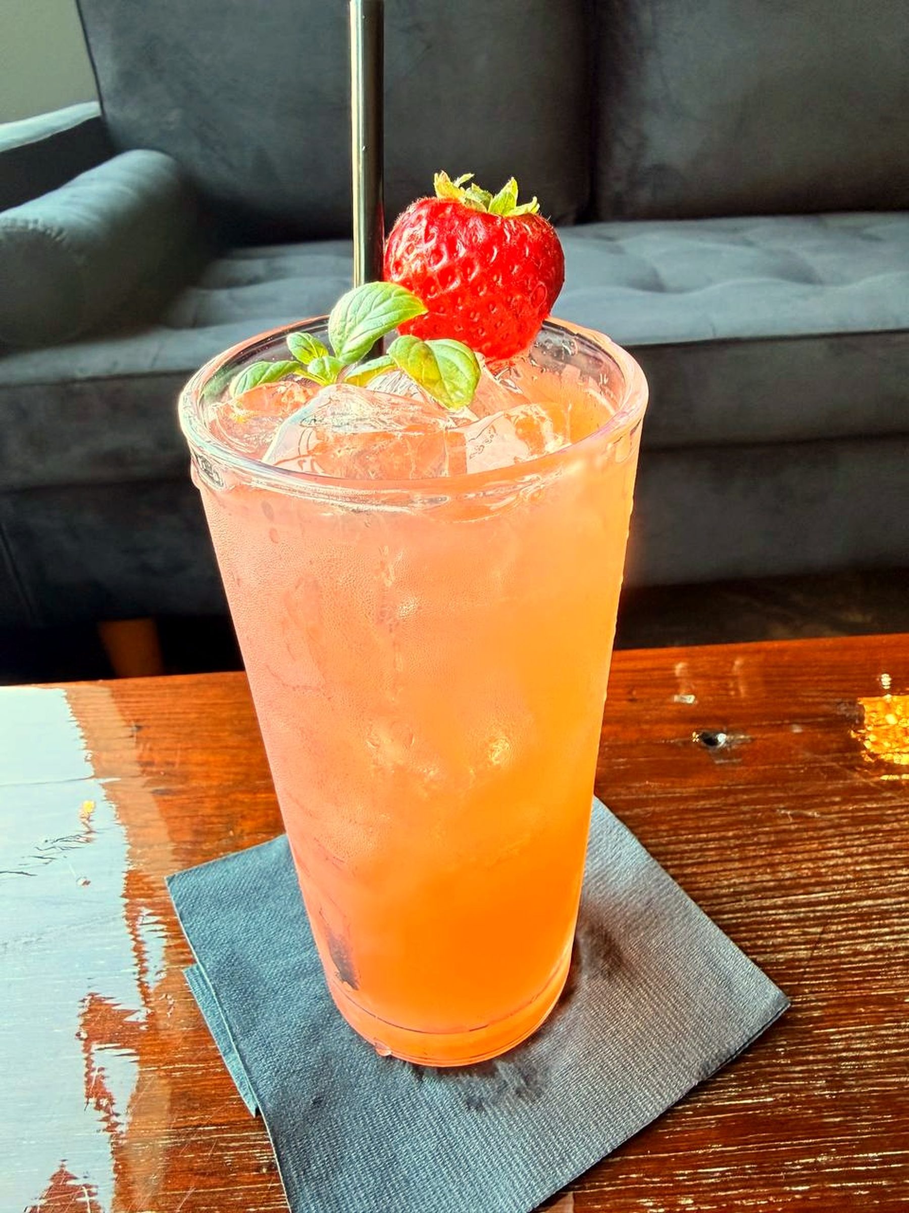 Cocktail with strawberry and mint garnish in the lounge seating area